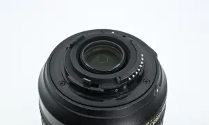 Zbliżenie na mocowanie obiektywu Nikon 18-105mm z widocznymi stykami i elementami optycznymi.