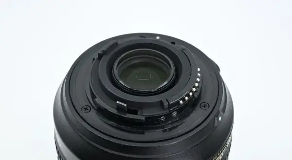 Zbliżenie na mocowanie obiektywu Nikon 18-105mm z widocznymi stykami i elementami optycznymi.